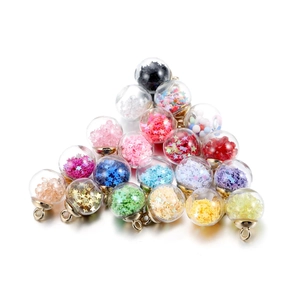 Macro shot of glass ball pendants filled with colorful sequins for DIY jewelry making