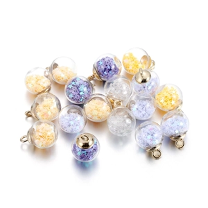Macro detail of glass ball pendants with colorful star sequins and golden metal caps
