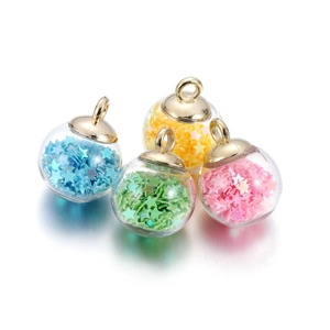 Detail of four glass ball pendants with colorful star sequins and golden caps for DIY jewelry