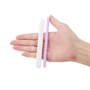 Hand holding white and purple silicone resin stirring rods for DIY crystal epoxy projects