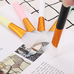 Multi-color silicone face mask brushes with golden metal ferrule on a stylish magazine