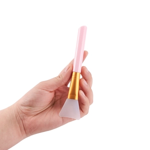 Pink silicone face mask brush with flat soft head and golden metal ferrule tool