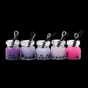 Cinque mini ciondoli bubble tea con sfumatura viola e anelli d'argento su sfondo nero