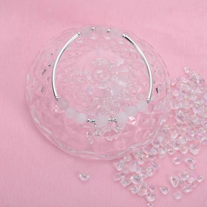 Detail eines Perlenarmbands mit silbernen Hohlrohren und facettierten rosa Kristallen