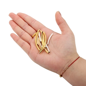 Dettaglio di tubi curvi in metallo oro e argento per la creazione di bracciali fai da te
