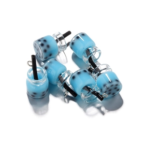 Dettaglio macro di mini ciondoli a bottiglia di bubble tea con resina blu e perle nere