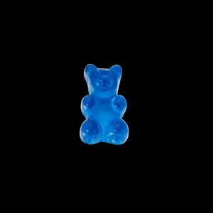Macro detail of a translucent blue resin gummy bear charm with glossy jelly texture