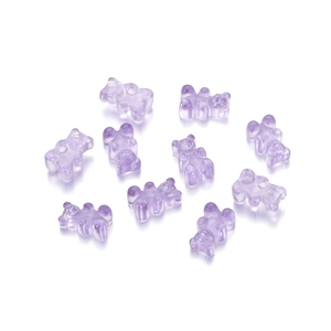 Close-up of translucent lavender resin bear beads for DIY jewelry with small drill holes