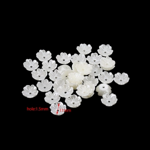Dettaglio macro di perle fiori bianchi 11mm con foro 1,5mm per creazione gioielli DIY
