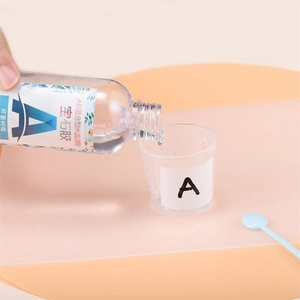 Detailopname van het gieten van heldere 3:1 epoxyhars in een gegradueerde maatbeker