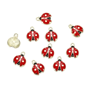 Macro-opname van rode emaille lieveheersbeestje bedeltjes voor DIY-sieraden en hobby's