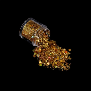 Macro shot of gold mixed sequins and glitter for nail art and DIY crafts in a clear jar