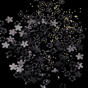 Detailed view of black resin 3D flowers and tiny golden steel beads for nail art DIY