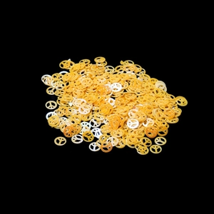 Macro shot of yellow and beige peace sign glitter sequins for DIY crafts and nail art