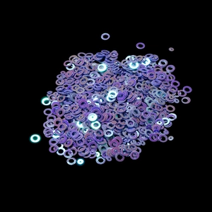 Macro detail of iridescent purple round sequins for DIY crafts and nail art decoration
