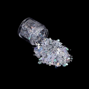 Macro shot of mixed holographic silver glitter flakes in a clear bottle for nail art DIY