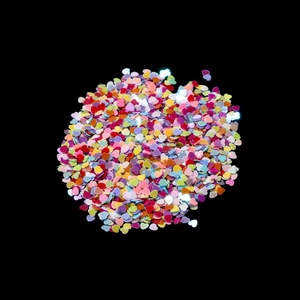 Macro shot of colorful heart-shaped glitter sequins for nail art on a black background