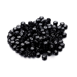 Nahaufnahme schwarzer Acryl-Rundperlen mit weißem Buchstaben G für DIY-Schmuck