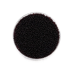 Vue macro de perles de rocaille en verre rouge foncé pour bijoux DIY en récipient