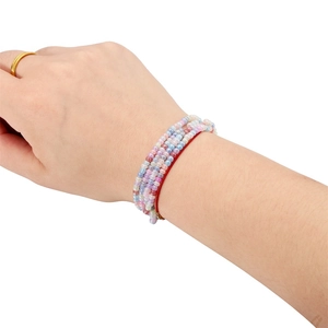 Primer plano de pulseras de cuentas de vidrio macarrón de 3mm con cordón rojo