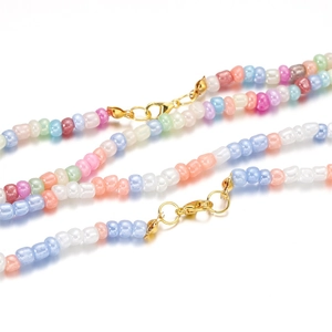 Collier de perles de rocaille macaron 4mm avec fermoir mousqueton doré sur fond blanc