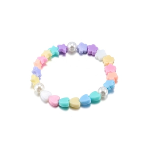 Dettaglio di perle acriliche color pastello a forma di cuore, stella e fiore con perle