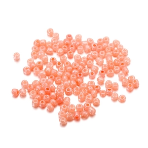 Vue macro de perles de verre rose corail pour création de bijoux et colliers DIY