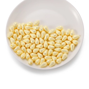 Détails macro de perles goutte à facettes en acrylique jaune crème pour bijoux DIY