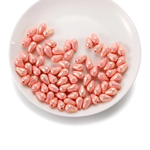 Détail des perles acryliques facettées en forme de goutte orange pêche irisé pour bijoux