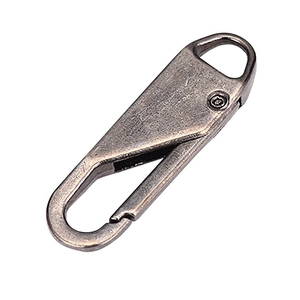 Detail view of vintage bronze alloy zipper pull with heavy duty metal carabiner hook