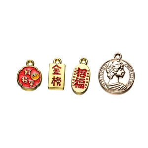 Detailed macro view of four alloy charms including Chinese blessing and 1987 coin pendant