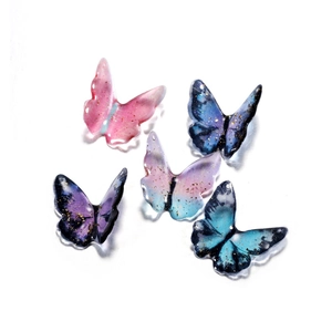 Top view of five colorful resin butterfly charms with gold foil and hanging holes