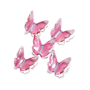 Close-up of pink translucent resin butterfly pendants with gold foil flakes and top hole