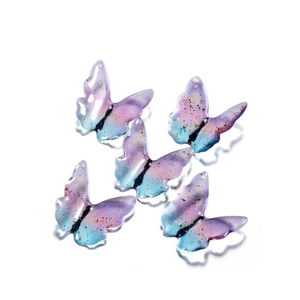 Detailed view of 5 purple and blue gradient resin butterfly pendants with gold foil flakes