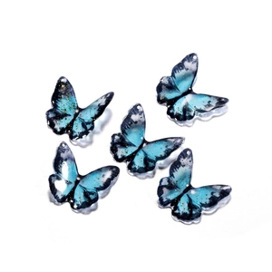 Detailed view of five blue butterfly resin pendants with gold flakes for jewelry DIY