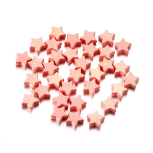 Détail de perles étoilées en acrylique pêche avec trous pour la création de bijoux DIY