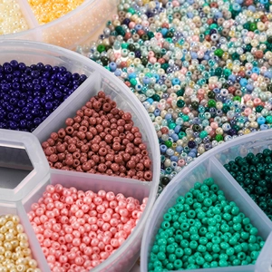 Detailansicht von 2mm Glasperlen in verschiedenen Farben in einer Plastiksortierbox
