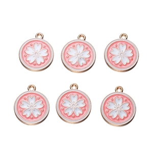 Close-up of six gold-plated cherry blossom pendants with pink enamel for DIY jewelry