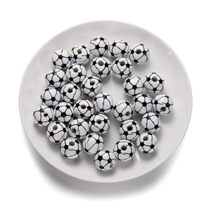 Gros plan de perles en bois motif football avec trous centraux sur une assiette blanche