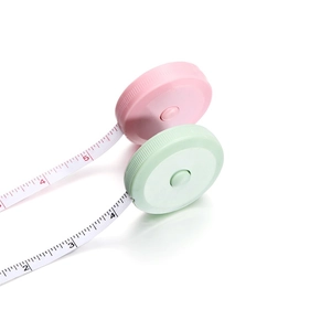 Macro view of pastel pink and mint green mini retractable soft measuring tapes