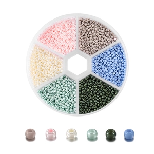 Makroansicht der 2mm Glasperlen in einer Sortierbox mit sechs Fächern für DIY-Schmuck