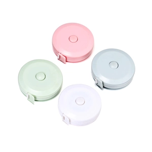 Close-up of colorful mini retractable measuring tapes in pink, green, grey, and white
