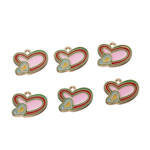 Close-up of pink enamel heart pendants for DIY jewelry making with gold-tone alloy hooks