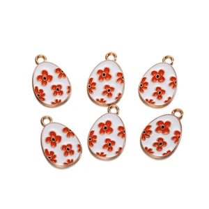 Detail of six white enamel egg charms with orange floral patterns for DIY jewelry