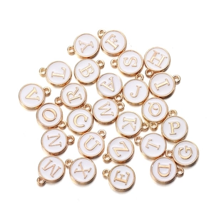 Detailed view of white enamel and gold alphabet pendants for DIY jewelry crafting