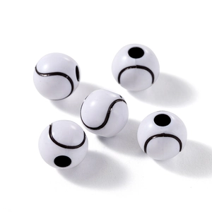 Gros plan de perles rondes en bois blanc avec motifs de baseball noirs et trous de fil