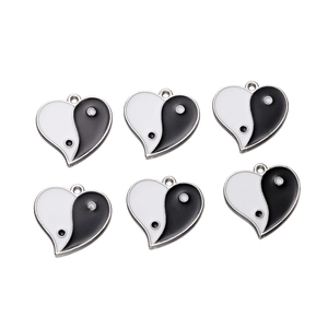Detail of six heart-shaped yin yang enamel charms in black and white with metal loops