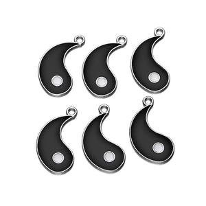 Detailed close-up of six yin-yang fish charms in black enamel and silver metal finish