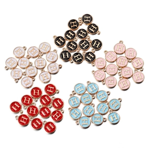 Detailed macro view of enamel alphabet H pendants in five colors with gold plating