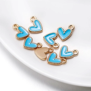 Gros plan de pendentifs cœur en émail bleu ciel avec bordure perlée dorée pour bijoux DIY